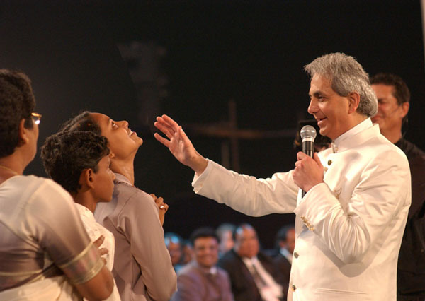 Benny Hinn on stage in India. He wanted money in return for his expences, and got a handsome amount. 