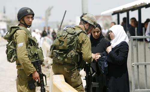 Palestinians wait to cross the Hawara checkpoint on the outskirts of the West Bank city of Nablus