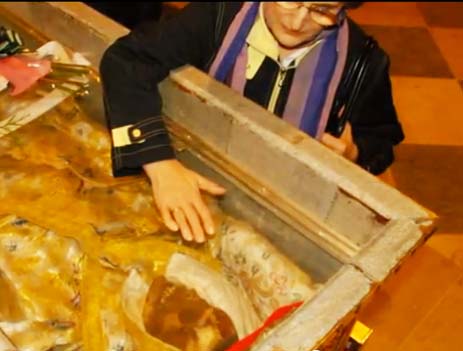 A Catholic faithful touches the glass protecting the 