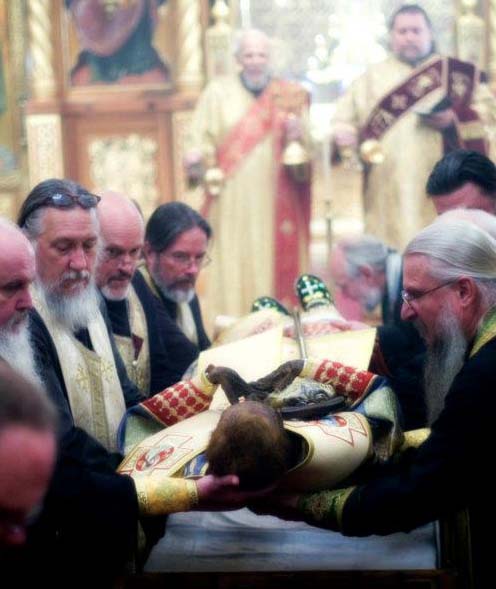 Religious men from Russia place the corpse for display in their chruch, after de redreessing is over.