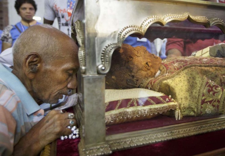 A poor Indian is lead into idolatry, paying to the mortal remains of a Spaniard. 