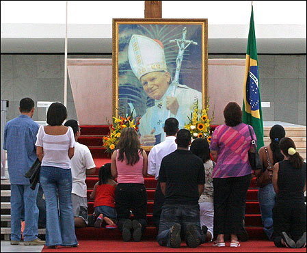 Bewitched Catholics kneel and worship their Pope. 