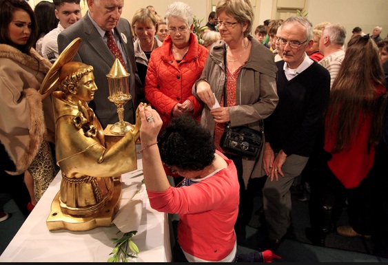 Kneeling down and praying, as the worshipers wait for a miracle. 