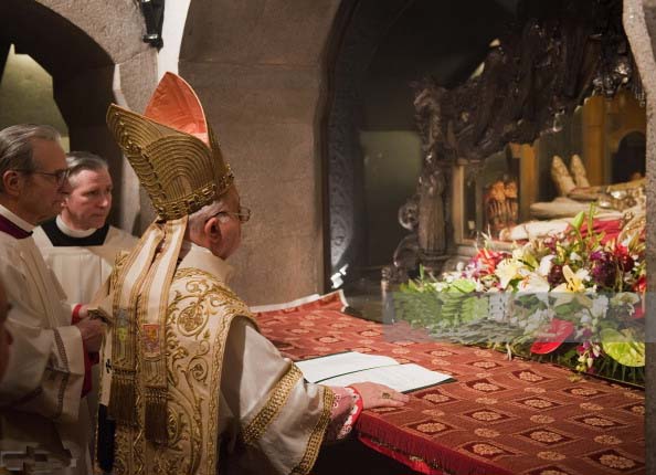 A Catholic Bishop conduct his religious ritials infront of the the corpses. 
