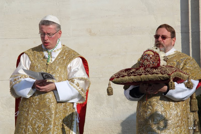 The Catholic priest sing a hymn before the outdoor mass will start. 
